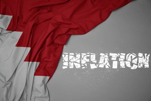 waving colorful national flag of bahrain on a gray background with broken text inflation. concept. 3d illustration