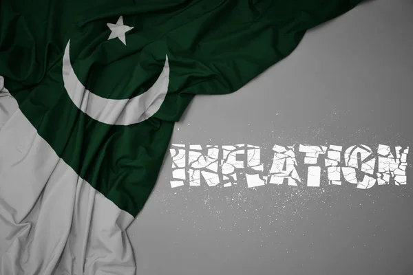 Mávání Barevnou Národní Vlajkou Pákistánu Šedém Pozadí Inflací Zlomeného Textu — Stock fotografie