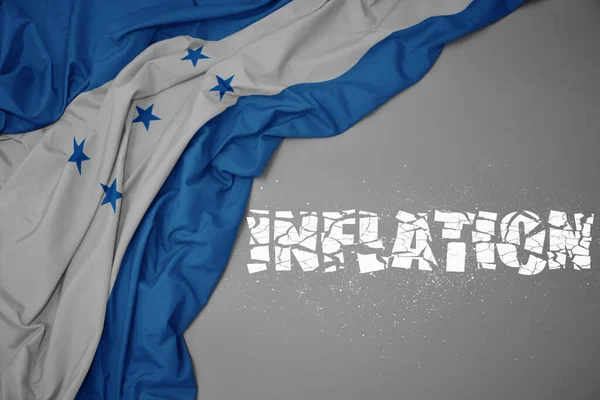 Mávání Barevnou Národní Vlajkou Hondurasu Šedém Pozadí Rozbitým Textem Inflace — Stock fotografie