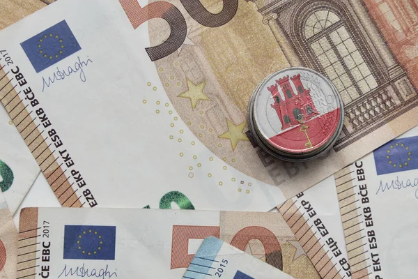 在欧元钞票背景上印有国徽的欧元硬币 — 图库照片