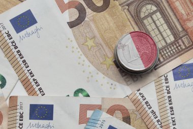 Avro para banknotlarının arka planında ulusal renkli malta bayrağı bulunan euro sikkesi