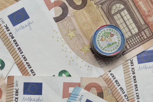 在欧元钞票背景上印有五颜六色的国旗的欧元硬币 — 图库照片