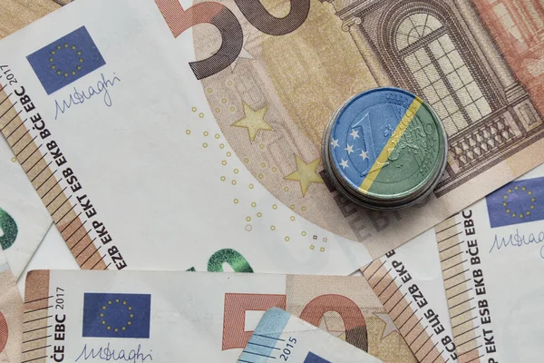 在欧元钞票背景上印有所罗门群岛国旗的欧元硬币 — 图库照片