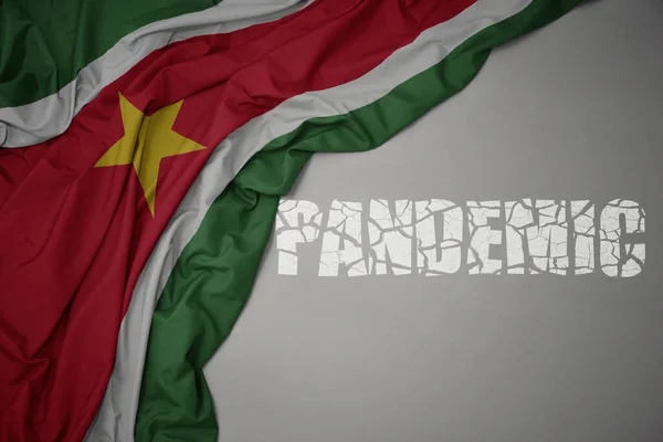 Ondeando Colorida Bandera Nacional Surinam Sobre Fondo Gris Con Pandemia —  Fotos de Stock