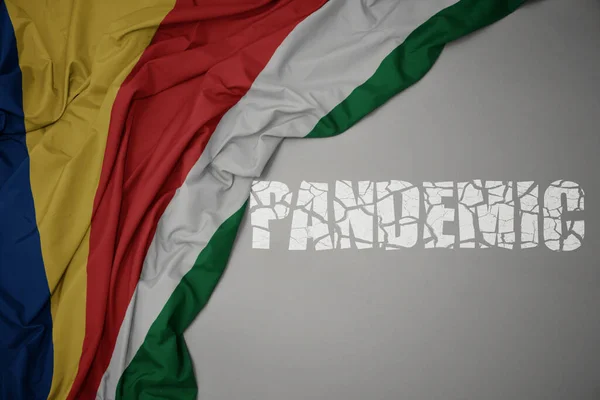 Machanie Barwną Flagą Narodową Seszeli Szarym Tle Przerwaną Pandemią Tekstową — Zdjęcie stockowe