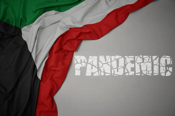 Размахивая Красочным Национальным Флагом Кувейта Сером Фоне Разбитой Текстовой Пандемией — стоковое фото