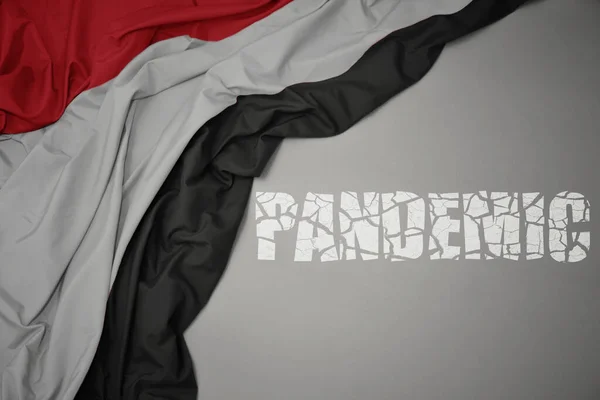 Mává Barevnou Národní Vlajkou Jemenu Šedém Pozadí Zlomeným Textem Pandemie — Stock fotografie