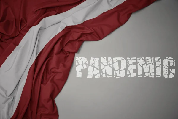 Acenando Bandeira Nacional Colorida Latvia Fundo Cinza Com Pandemia Texto — Fotografia de Stock
