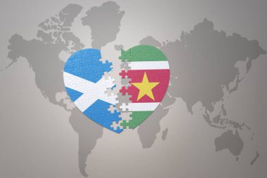 Dünya haritasında Surinam ve İskoçya 'nın ulusal bayrağını taşıyan bir bulmaca kalbi. 3B illüstrasyon
