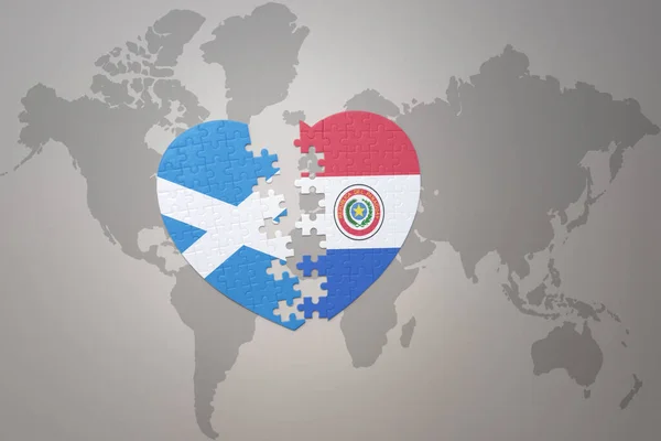 stock image puzzle heart with the national flag of paraguay and scotland on a world map background.Concept. 3D illustration