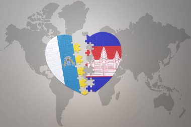 Kamboçya 'nın ulusal bayrağı ve Kanarya Adaları' nın yapboz kalbi bir dünya haritası üzerinde. 3B illüstrasyon