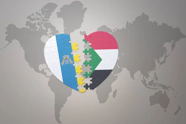 世界地図の背景にスーダンとカナリア諸島の国旗が描かれたパズルハート 3Dイラスト — ストック写真