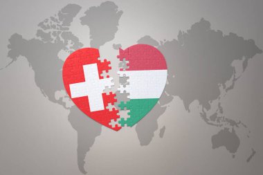 Hungary ve İsviçre 'nin ulusal bayrağıyla bir dünya haritasında yer alan bulmaca kalbi. 3B illüstrasyon