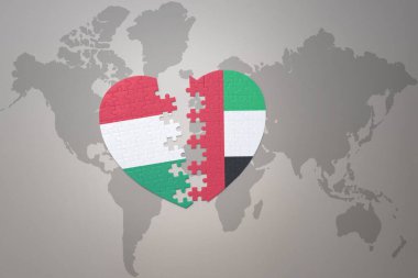 Birleşik Arap Emirlikleri 'nin ulusal bayrağını taşıyan bir bulmaca kalbi ve bir dünya haritasında Hungary. 3B illüstrasyon