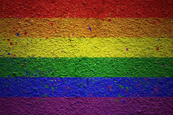 巨大な古い割れた壁にカラフルな虹色のゲイのプライドフラグを描いた — ストック写真