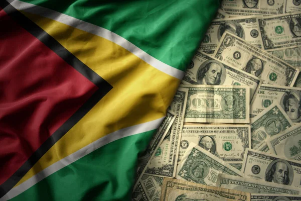 stock image big colorful waving national flag of guyana on a american dollar money background. finance concept