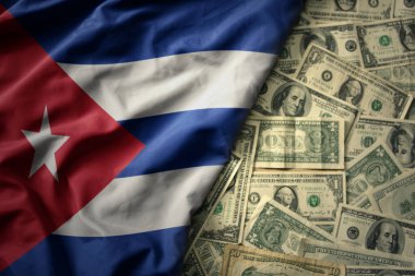 Büyük renkli bir Küba bayrağını Amerikan dolarları üzerinde sallıyor. finans kavramı