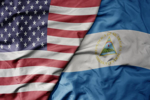 big waving colorful flag of united states of america and national flag of nicaragua . macro