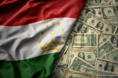 Tacikistan 'ın ulusal bayrağını Amerikan dolarının arka planında sallayan büyük renkli bir bayrak. finans kavramı