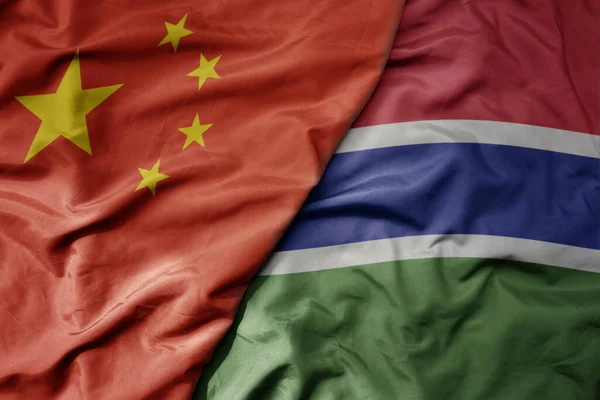 stock image big waving national colorful flag of china and national flag of gambia . macro