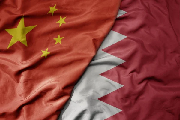 big waving national colorful flag of china and national flag of bahrain . macro