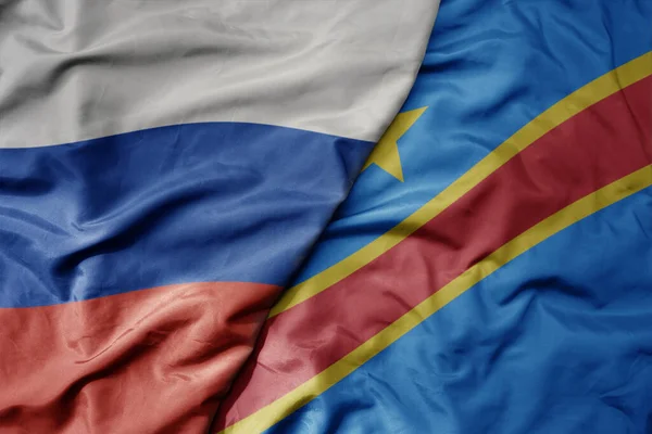 stock image big waving realistic national colorful flag of russia and national flag of democratic republic of the congo . macro