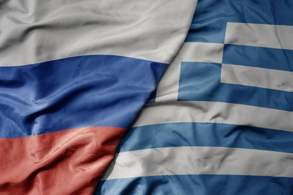 big waving realistic national colorful flag of russia and national flag of greece . macro