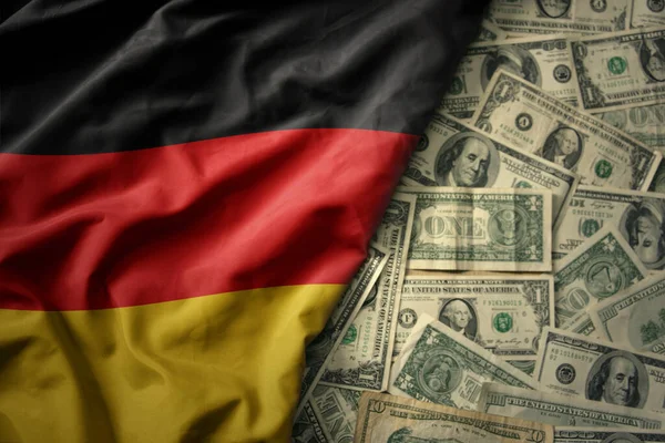 stock image big colorful waving national flag of germany on a american dollar money background. finance concept