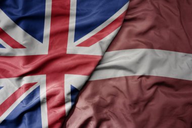 Büyük Britanya bayrağı ve Letonya 'nın ulusal bayrağı sallanıyor. makro