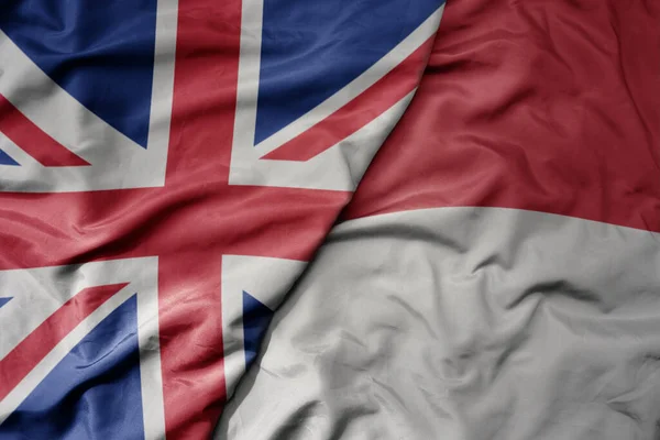 大摇大摆的五彩缤纷的英国国旗和印度尼西亚国旗 — 图库照片