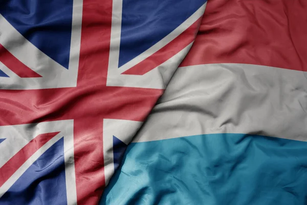 Большой Размахивая Национальным Красочным Флагом Великобритании Национальным Флагом Луксембурга Macro — стоковое фото
