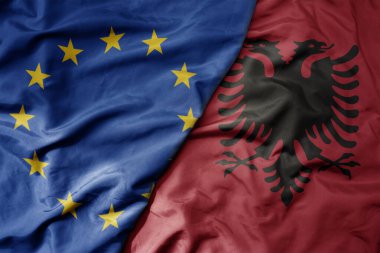 Avrupa Birliği 'nin ve Arnavutluk' un ulusal bayrağının gerçekçi ulusal bayrağını sallıyor. makro
