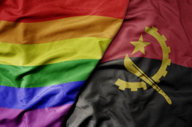 Angola 'nın ulusal renkli bayrağı ve gökkuşağı eşcinsellik gururu bayrağı sallanıyor. makro