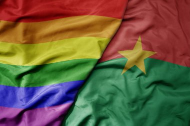 Burkina faso ve gökkuşağı eşcinsellik bayrağının büyük, gerçekçi ulusal bayrağını sallıyor. makro