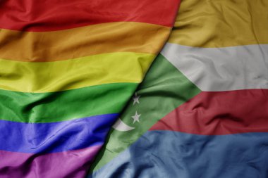 Büyük, gerçekçi, renkli komoro bayrağı ve gökkuşağı eşcinsellik gururu bayrağı sallıyor. makro