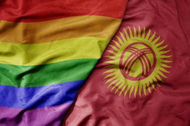 Kırgızistan ve gökkuşağı eşcinsellik bayrağının büyük, gerçekçi ulusal bayrağını sallıyor. Makro. Tarihi bayrak