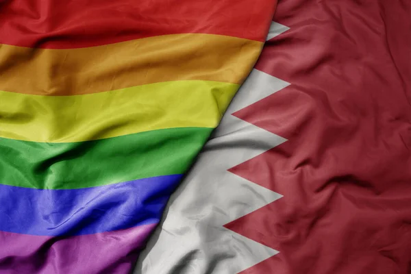 big waving realistic national colorful flag of bahrain and rainbow gay pride flag . macro