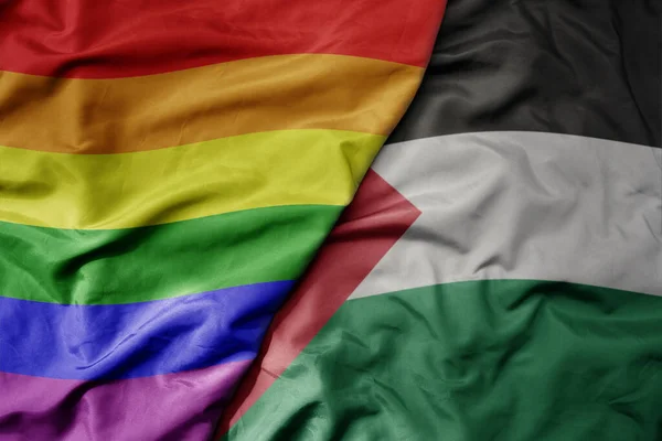 パレスチナと虹のゲイのプライドフラッグの大きな波現実的な国家カラフルな旗 マクロ マクロ ロイヤリティフリーのストック写真