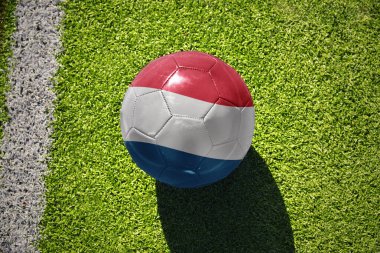 Lüksemburg 'un ulusal bayrağını taşıyan futbol topu beyaz çizginin yanındaki yeşil alanda