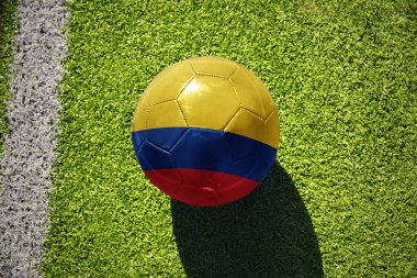 Beyaz çizginin yanındaki yeşil alanda Kolombiya bayrağı taşıyan futbol topu.