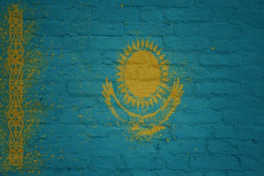 Kazakistan 'ın büyük ulusal bayrağını büyük, eski, renkli bir tuğla duvara boyamış.