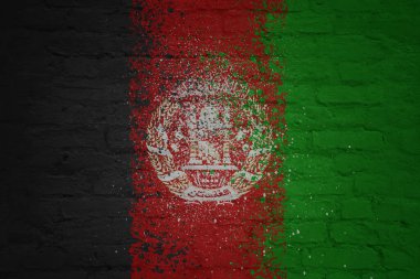 Büyük, eski bir tuğla duvarın üzerine kocaman bir Afganistan bayrağı boyanmış.