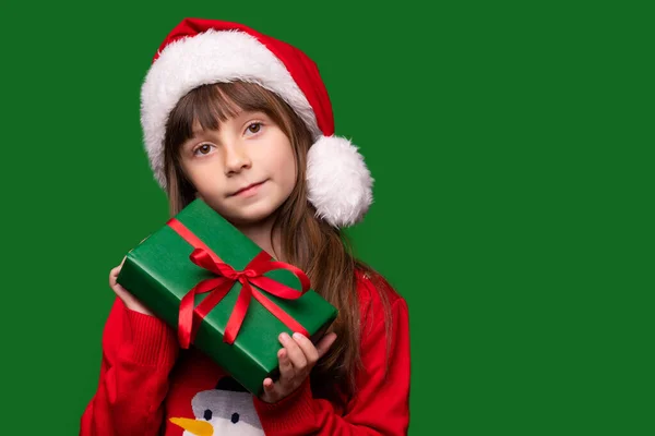 Mała Dziewczynka Trzyma Prezent Zielonym Odosobnionym Tle Dziecko Kapeluszu Świętego — Zdjęcie stockowe