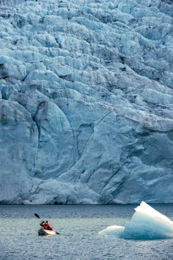 Arka planda Folgefonna Buzulu ile Mosevatnet Gölü 'nde kayak yapan genç kadın Norveç' i ziyaret ediyor. 