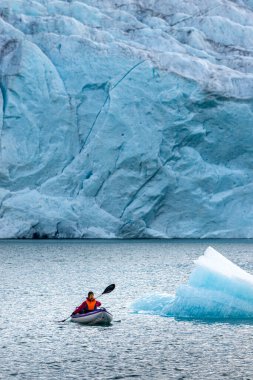 Arka planda Folgefonna Buzulu ile Mosevatnet Gölü 'nde kayak yapan genç kadın Norveç' i ziyaret ediyor. 