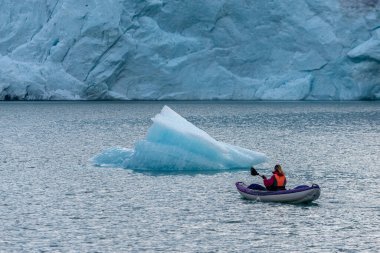 Arka planda Folgefonna Buzulu ile Mosevatnet Gölü 'nde kayak yapan genç kadın Norveç' i ziyaret ediyor. 