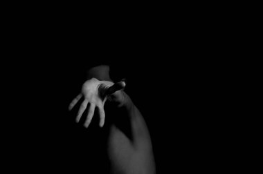 Siyah arka planda etkileyici bir duruşu olan genç bir adam.