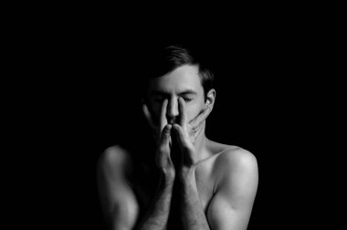 Siyah arka planda etkileyici bir duruşu olan genç bir adam.