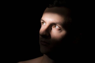 Siyah arka planda bir adamın portresi.