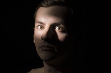 Siyah arka planda bir adamın portresi.